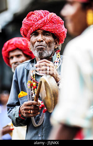 Udaipur, Indien, 14. September 2010: alte indische Mann mit Turban Musizieren mit seiner Gruppe auf einer Straße. Stockfoto