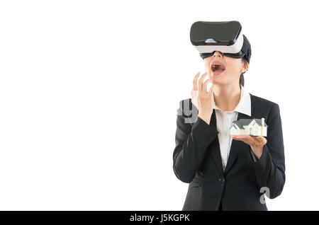 junge Geschäftsfrau in virtual-Reality-Helm anzeigen 3d Video Brille Bildschirm unwohl mit wenig Hausmodell ist schockierend Stockfoto