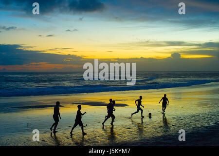 Menschen Palying Fußball am Strand bei Sonnenuntergang. Insel Bali, Indonesien Stockfoto