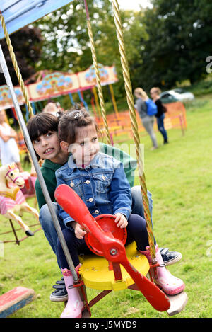 Bruder und Schwester auf Flugzeug Messegelände fahren (Brighton Apple Day, Stanmer Park, Stockfoto