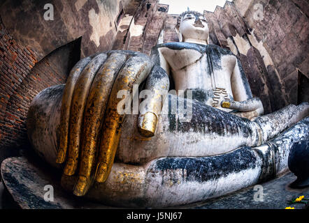 Riesige Buddha-Statue Phra Achana in Wat Si Chum in grau bedecktem Himmel in Sukhothai Historical Park, Thailand anrufen Stockfoto