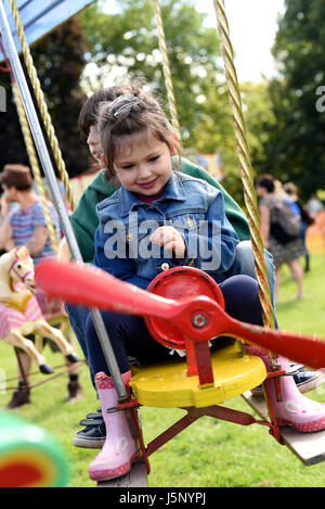 Bruder und Schwester auf Flugzeug Messegelände fahren (Brighton Apple Day, Stanmer Park, Stockfoto