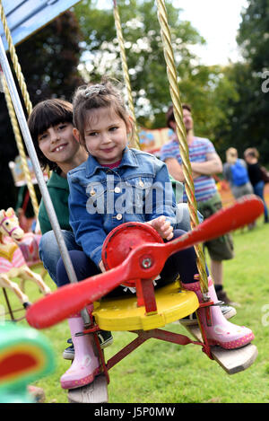 Bruder und Schwester auf Flugzeug Messegelände fahren (Brighton Apple Day, Stanmer Park, Stockfoto