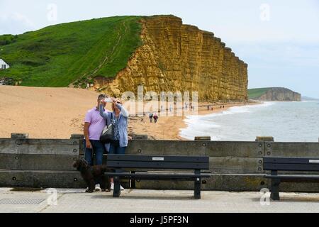 West Bay, Dorset, UK. 18. Mai 2017. Großbritannien Wetter. Ein paar am Pier Ost, wobei eine Selfie in Fron zu den berühmten Klippen von Broadchurch an einem Tag diesig Sonnenstrahlen im Badeort von West Bay in Dorset. Bildnachweis: Graham Hunt/Alamy Live-Nachrichten Stockfoto