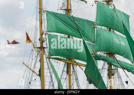 Charleston, USA. 18. Mai 2017. Ein US-Küstenwache Hubschrauber fliegt vorbei an den massiven Segeln die deutsche Bark Alexander von Humboldt II während der Parade der Segel zum Auftakt der hohen Schiffe Charleston Festival 18. Mai 2017 in Charleston, South Carolina. Das Fest der großen Segelschiffe von auf der ganzen Welt verbringen drei Tage besuchen historische Charleston. Bildnachweis: Planetpix/Alamy Live-Nachrichten Stockfoto