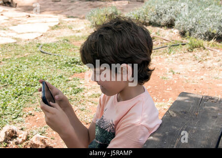 Niedlichen kleinen Jungen spielen mit mobilen Gerät Stockfoto