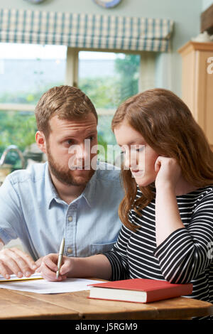 Männlich-Home Tutor hilft Mädchen kämpfen mit Studien Stockfoto