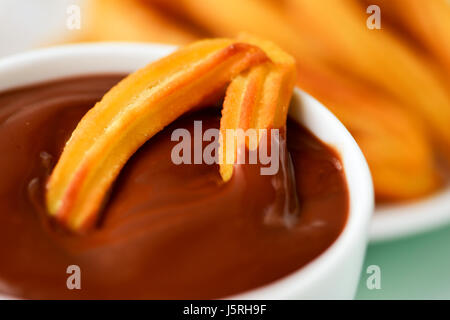 Churros con Chocolate, eine typisch spanische süße Jause, auf einem Tisch Stockfoto