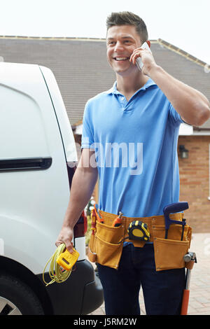Elektriker mit Van telefonieren mit Handy vor Haus Stockfoto