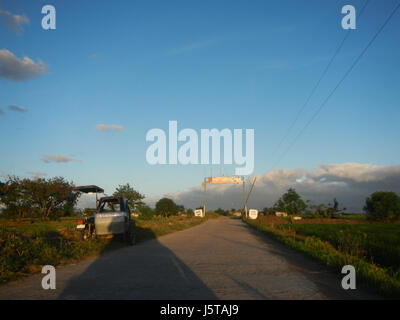 Dieses Bild bezieht sich auf den Cuayang Bugtong Welcome Arch in Candaba, Pampanga, Philippinen. Der Bogen ist ein markantes Wahrzeichen und markiert den Eingang zur Bauerngemeinde, die für ihre landwirtschaftlichen Felder und Marktstraßen bekannt ist. Stockfoto