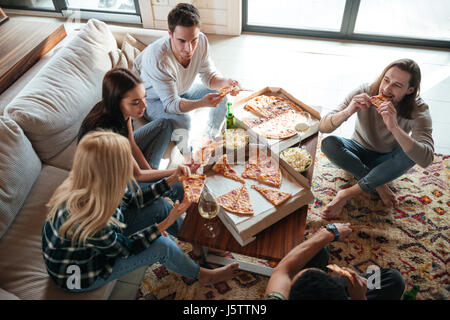 Draufsicht eines befreundeten fünf sind auf Sofa sitzen und Essen Pizza im Haus Stockfoto