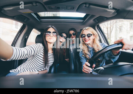 Gruppe von Mädchen, die Spaß im Auto und nehmen Selfies mit Kamera Stockfoto