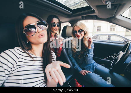 Gruppe von Mädchen, die Spaß im Auto und nehmen Selfies mit Kamera Stockfoto