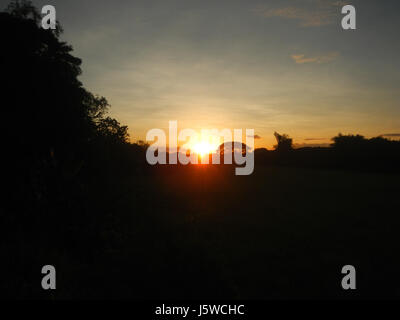 Dieses Bild fängt den lebendigen Sonnenuntergang in Galas, Maasim, San Rafael, Bulacan, Philippinen ein. Diese ländliche Gegend ist bekannt für ihre malerische Landschaft und bietet einen atemberaubenden Blick auf die untergehende Sonne über die umliegenden Felder und Hügel. Stockfoto