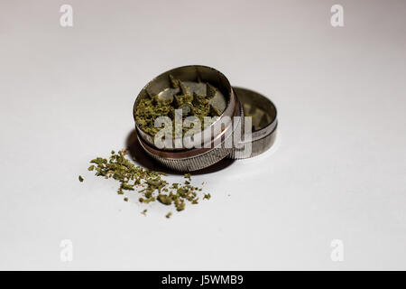 Grinder mit Unkraut innen geöffnet, alle auf einem grauen Hintergrund verblassen Stockfoto