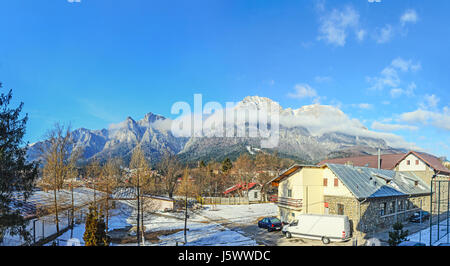 Karpaten Blick vom Busteni Stadt, Bucegi mit Kreuz in Spitze des Caraiman Peak, Wolken, Schnee und Nebel, Zeit Winterlandschaft. Stockfoto