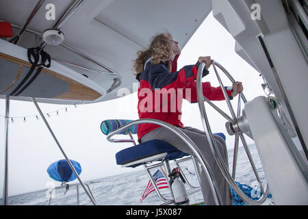 Junge Frau Kapitäne eine Segelyacht Boot bei schlechtem Wetter Regen und Sturmböen Stockfoto