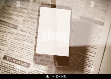 Fake-Zeitung und Smartphone mit leeren Bildschirm. Business-Kommunikation-Konzept. Stockfoto
