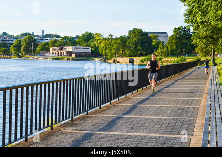 Washington DC, USA - 15. August 2013: Mann Joggen vom Potomac River mit Skyline von Georgetown auf Bürgersteig Stockfoto