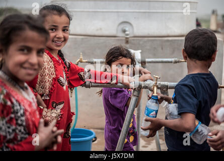 Kinder stehen an einem Wassertank im Khazir Refugee Camp Irak Stockfoto