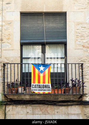 Katalanische nationalistische Flagge hängen über dem Balkon eines Mehrfamilienhauses in Girona-Katalonien-Spanien. Stockfoto