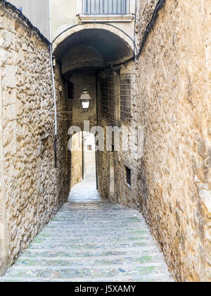 Eine schmale Stein gepflastert Durchgang zwischen Kalksteinwänden, Girona, Spanien. Stockfoto