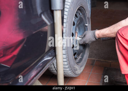 Reifenwechsel in der Kfz-Reparatur - Auto auf Hebebühne Stockfoto