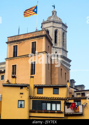 Die katalanische Flagge über ein Gebäude mit dem Glockenturm der Kathedrale von Girona im Hintergrund, Girona, Spanien. Stockfoto