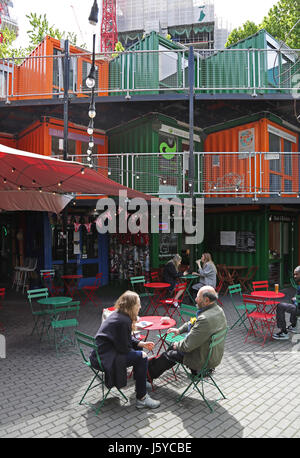 Ein paar sitzen in einem Café im Elephant Kunstwerke, eine Entwicklung von Geschäften, Büros und Cafés in Südlondon aus Schiffscontainern konstruiert. Stockfoto
