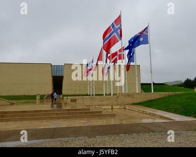 Paare, die in Memorial Museum, mit verschiedenen Fahnen, an einem regnerischen Tag in Caen, Frankreich. Stockfoto