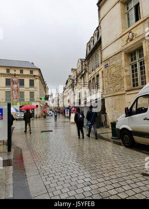 Menschen zu Fuß in den Regen, mit Sonnenschirmen, Fußgängerzone, rue Saint-Pierre, Caen, Frankreich. Stockfoto