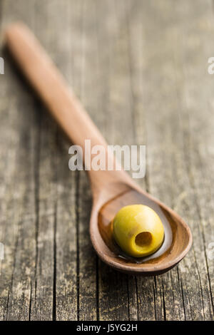 Die grünen Oliven in Holzlöffel. Stockfoto