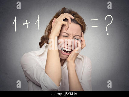 gestresste Frau lösen nicht Mathe finanzielles Problem isoliert auf graue Wand Hintergrund. Menschlichen Gesichtsausdruck, Emotionen, Gefühle Stockfoto