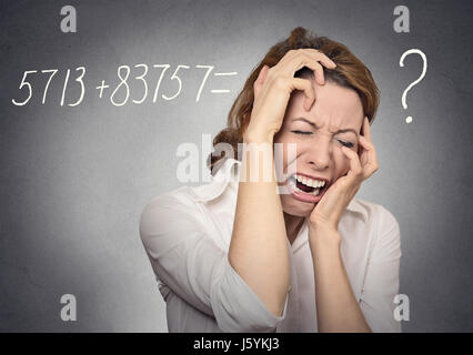 Gestresste weinende Frau lösen nicht mathematische Problem im Kopf auf graue Wand Hintergrund isoliert. Menschlichen Gesichtsausdruck, Emotionen, Gefühle Stockfoto