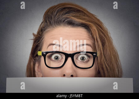 Banner Zeichen Frau spähen über Rand der leeren Blankopapier Plakatwand. Schöne junge Frau mit Brille schauen überrascht und erschrocken lustig mit breiten op Stockfoto