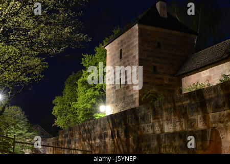 Beleuchtete mittelalterliche Festungsmauern der Nürnberger Burg bei Nacht. Nürnberg, Bayern, Deutschland Stockfoto