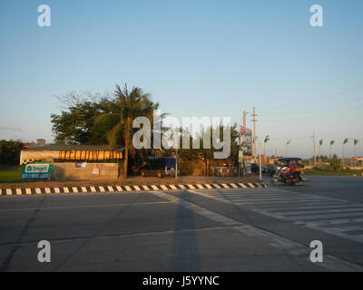 Dieser Eintrag bezieht sich auf die Umleitungsstraße und die Infrastrukturentwicklung um Tabe, Guiguinto, Bulacan, Philippinen. Sie hebt wichtige Straßen, einschließlich der Stadtstraße 21, und ihre Rolle in den lokalen Landwirtschafts- und Verkehrssystemen hervor. Stockfoto