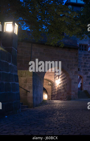 Beleuchtete mittelalterliche Festungsmauern der Nürnberger Burg am frühen Morgen. Nürnberg, Bayern, Deutschland. Stockfoto