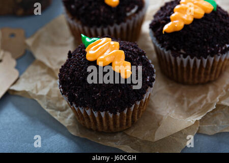 Karotten-Muffins mit Schokolade Krümel und Zuckerguss Stockfoto