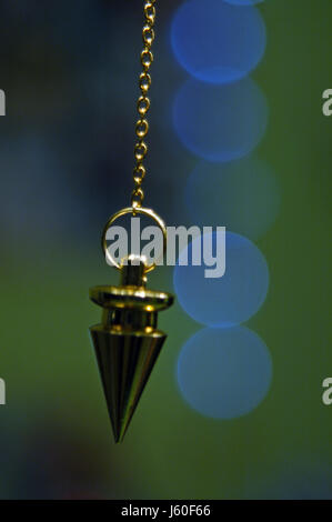 goldene Kette Esoterik Pendel schwingen schwingen BlueMotion Verschiebung bewegen Stockfoto