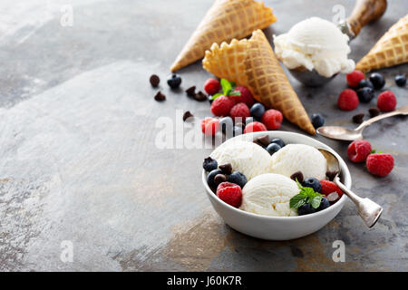 Vanille-Eis-Kugeln in eine Schüssel mit frischen Beeren Stockfoto