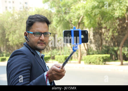 Junge indische Unternehmen Mann im Anzug nehmen Selfie mit Selfie stick Stockfoto