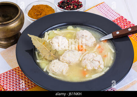 Suppe mit Nudeln und Fleischklößchen in Ablack Platte. Studio Photo Stockfoto