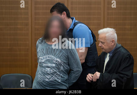 Frankfurt am Main, Deutschland. 19. Mai 2017. Ein Gericht geordnete nimmt die Handschellen aus der Beschuldigten Hölle die Engels Hände (L), als er die Sicherheit Halle des Bezirksgerichts vor Beginn des Verfahrens in Frankfurt Am Main, Deutschland, 19. Mai 2017 betritt. Auf der rechten Seite steht der Angeklagte Verteidigers, Michael Oberwinder. Die Staatsanwaltschaft beschuldigt den Mann, die-zusammen mit Komplize noch auf die Lauf - Schuss und schwer verwundet Bande zwei weitere Mitglieder des Motorrads Szene letztes Jahr in der Frankfurter Innenstadt. Bildnachweis: Dpa picture Alliance/Alamy Live News Stockfoto