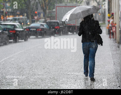 München, Deutschland. 19. Mai 2017. Eine Frau mit einem Regenschirm geht durch ein Hagelsturm in München, 19. Mai 2017. Foto: Florian Eckl/Dpa/Alamy Live News Stockfoto