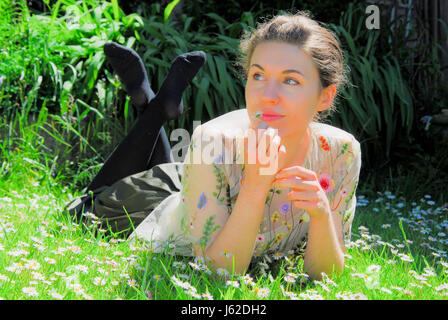 Portland, Dorset, UK. 19. Mai 2017. Sophie, 21, feiert das Ende ihres Studiums, genießen Sie die Sonne in einem Feld von Gänseblümchen, Portland, Dorset Credit: Stuart Fretwell/Alamy Live-Nachrichten Stockfoto