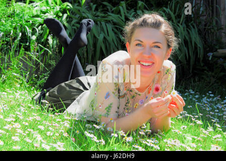 Portland, Dorset, UK. 19. Mai 2017. Sophie, 21, feiert das Ende ihres Studiums, genießen Sie die Sonne in einem Feld von Gänseblümchen, Portland, Dorset Credit: Stuart Fretwell/Alamy Live-Nachrichten Stockfoto