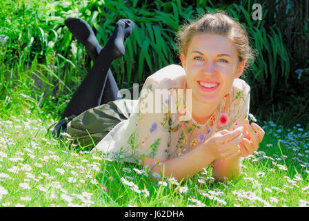 Portland, Dorset, UK. 19. Mai 2017. Sophie, 21, feiert das Ende ihres Studiums, genießen Sie die Sonne in einem Feld von Gänseblümchen, Portland, Dorset Credit: Stuart Fretwell/Alamy Live-Nachrichten Stockfoto