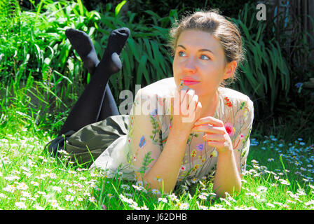 Portland, Dorset, UK. 19. Mai 2017. Sophie, 21, feiert das Ende ihres Studiums, genießen Sie die Sonne in einem Feld von Gänseblümchen, Portland, Dorset Credit: Stuart Fretwell/Alamy Live-Nachrichten Stockfoto