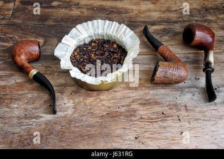 Hölzernen Pfeifen und Tabak in die Metall-Box auf einem Holztisch. Stockfoto